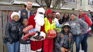 Members of The Seattle Magic Wheels Motorcycle Club, along with members of the Genuine Queens, pose with kids from some of the families that they adopted for Christmas. Courtesy Photo.