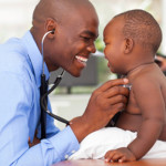 African-male doctor examining baby boy. Photo.Think Sock.