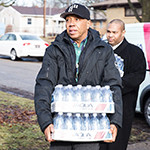 Russell Simmons delivers water to victims of Flint water crisis. Photo/Kory Woods/Michigan Chronicle/NNPA.