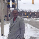 U. S. Black Chamber President/CEO Ron Busby stands near the Flint campus of the University of Michigan, which he said was working fine while Black businesses suffered.